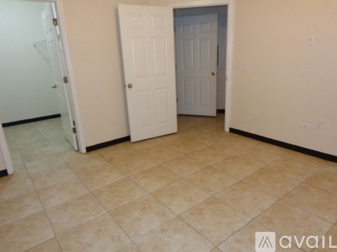A room with a tiled floor and two doors.