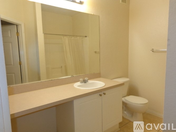 A bathroom with a sink, toilet and mirror.