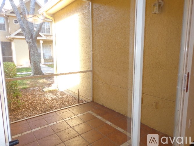 A balcony with a view of a tree and a house.