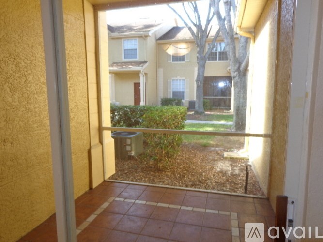 A balcony with a tiled floor and a bush in the middle.