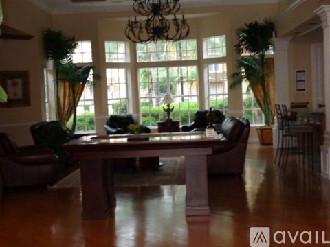 A living room with a table and chairs in front of a large window.
