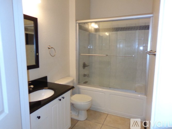 A bathroom with a toilet, sink, and shower.