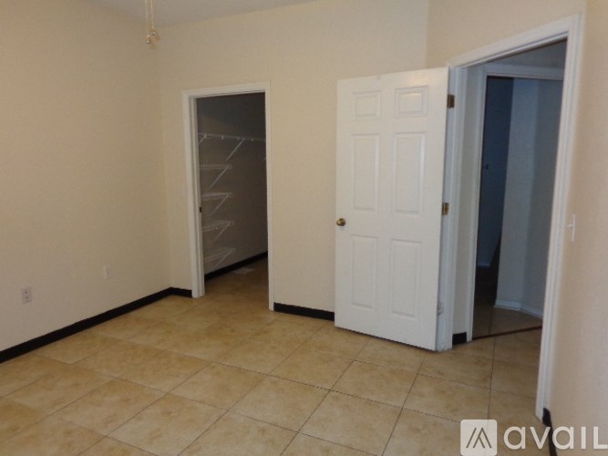 A room with a white door and a white closet with a shelf.