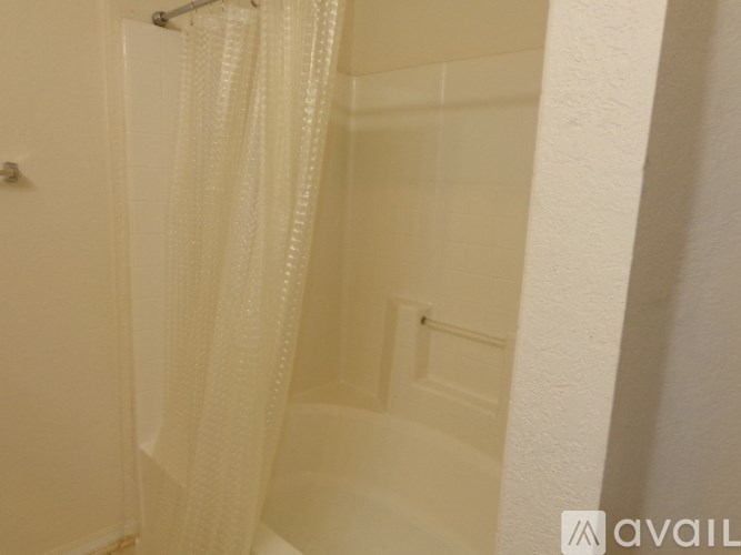 A white bathroom with a shower curtain and a door.