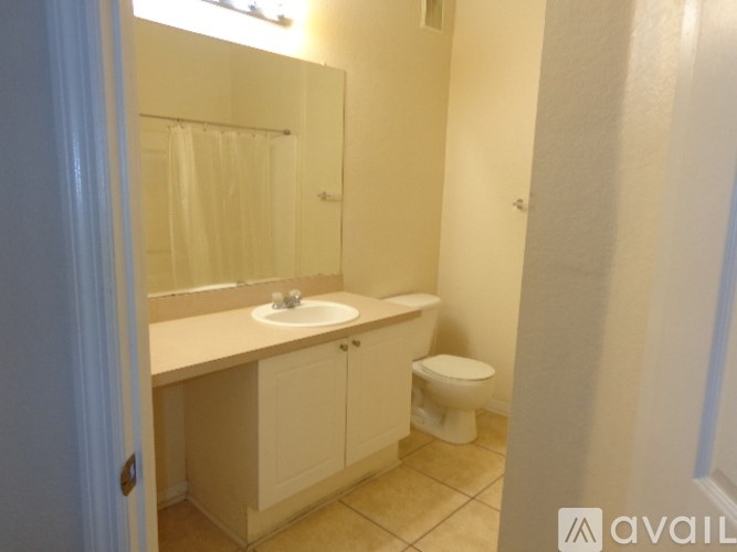 A bathroom with a sink, toilet and mirror.