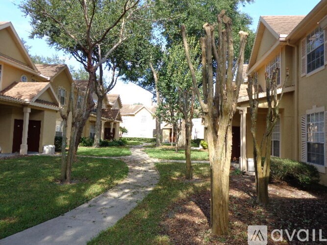 A row of houses with trees in front of them.