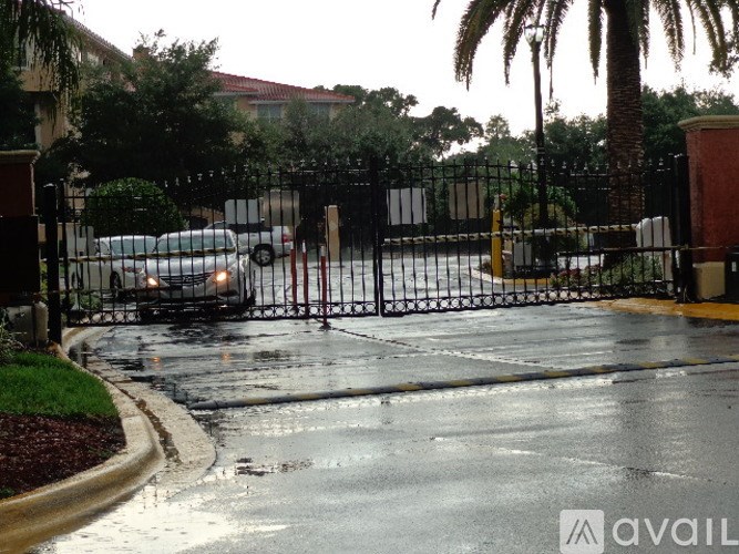 A gated entrance to a building with a wet ground.