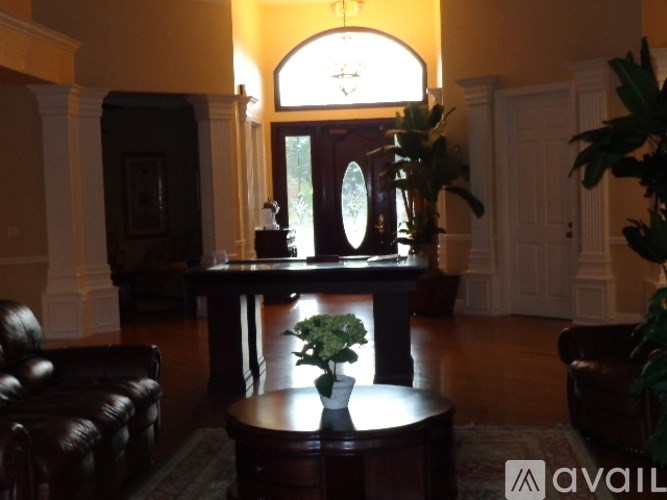 A living room with a brown leather couch, a wooden coffee table, and a large mirror on the wall.