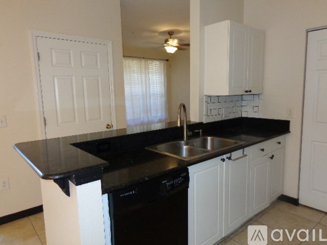 A kitchen with black countertops and white cabinets.
