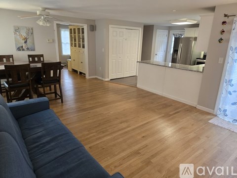 A living room with a blue couch and a dining table.