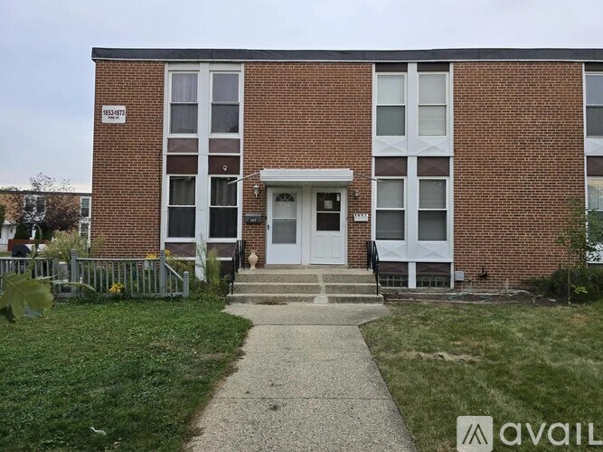 A brick building with a white door and windows.