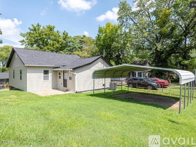 A house with a carport and a car parked in front.