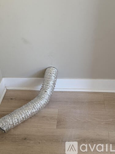 A flexible duct is laying on the floor.