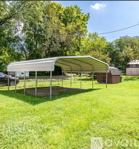 A white canopy structure is set up in a grassy field.