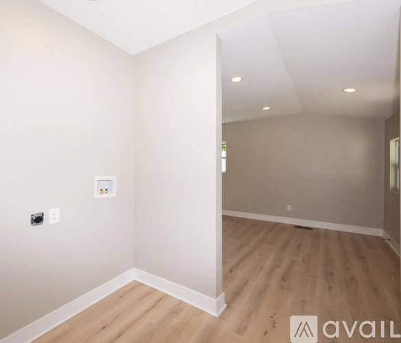 A room with wooden flooring and white walls.