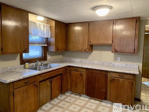 A kitchen with wooden cabinets and a marble countertop.