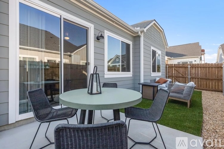 A patio with a table and chairs is set up outside a house.