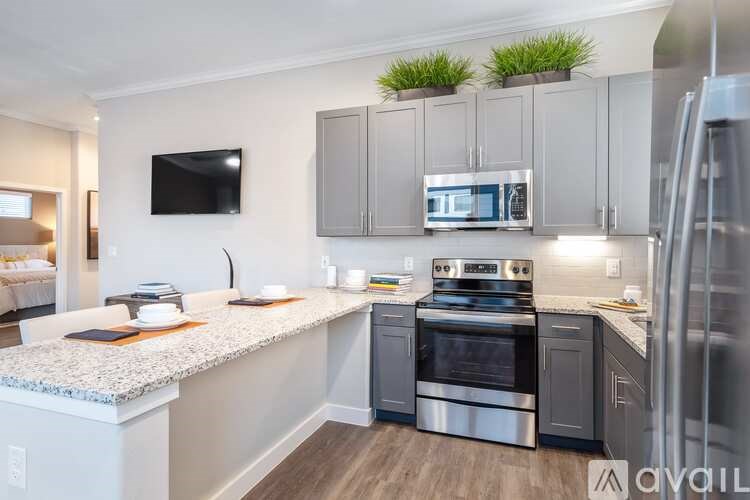 A kitchen with a granite countertop and stainless steel appliances.