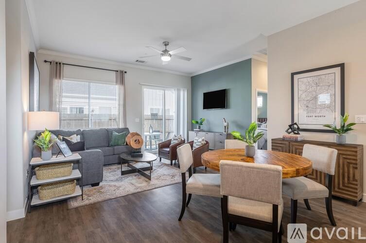 A living room with a grey couch, a wooden table, and a ceiling fan.