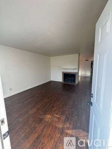 A room with wooden floors and a white door.