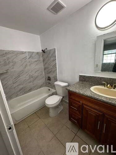 A bathroom with a toilet, sink, and bathtub.