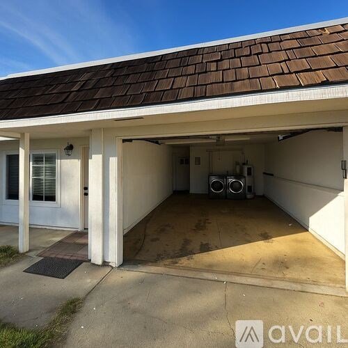 A garage with a brown roof and a white door is available for rent.