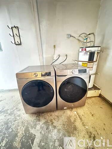 Two front loading washing machines in a room with white walls.