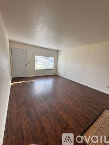 A room with wooden flooring and a white door.