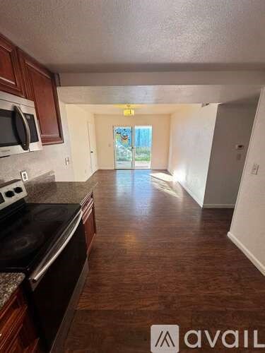 A kitchen with dark wood cabinets and a black stove top oven.