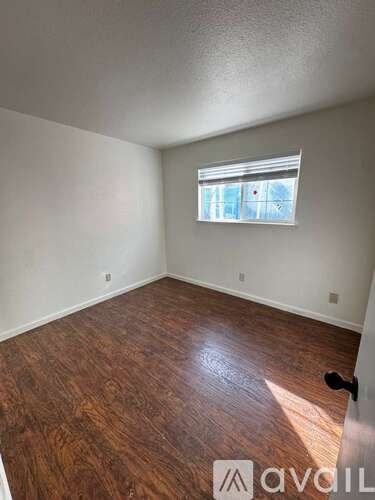 A room with wooden flooring and a window.