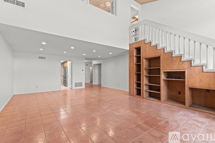 A spacious room with a staircase and a tiled floor.