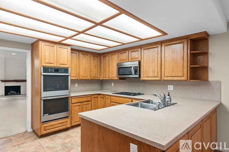 A kitchen with wooden cabinets and a granite countertop.
