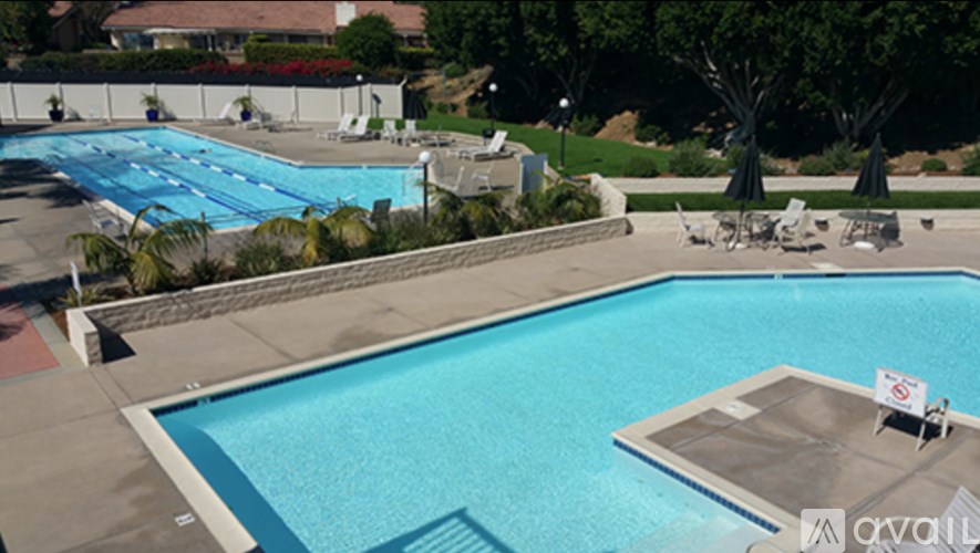 A large swimming pool with a sign that says "available" in the foreground.