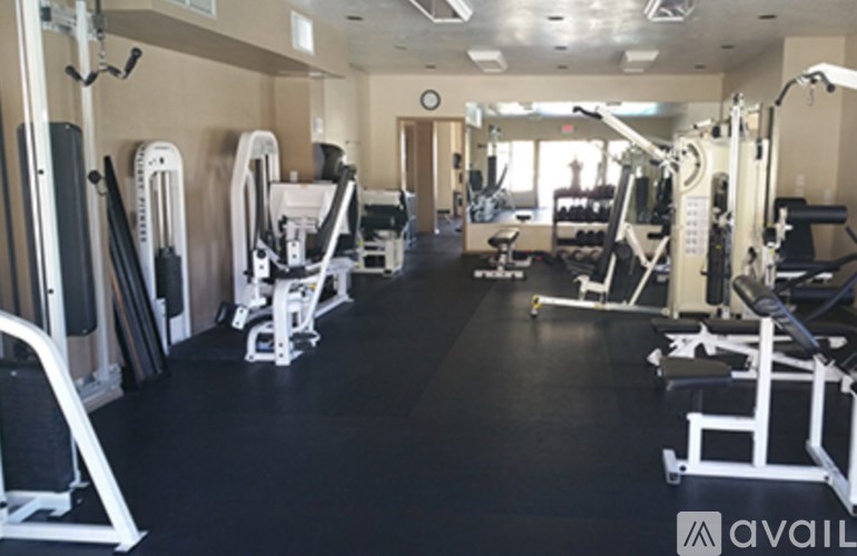 A gym with a variety of equipment including treadmills, weights, and exercise machines.