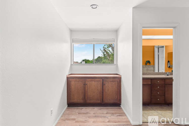 A room with a window and a wooden cabinet.
