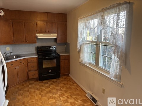A kitchen with wooden cabinets and a black oven.