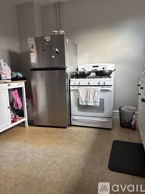 A kitchen with a stainless steel refrigerator and stove top oven.