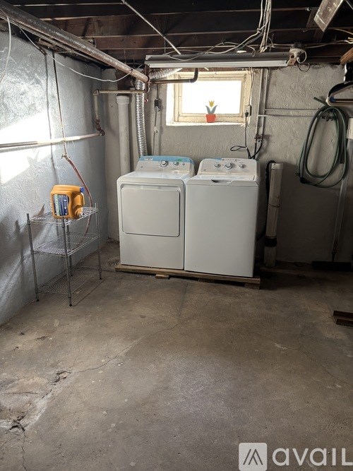 A room with a water heater and a tank.