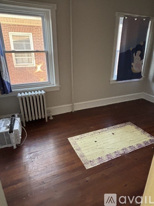 A room with a window, a radiator, and a fan.