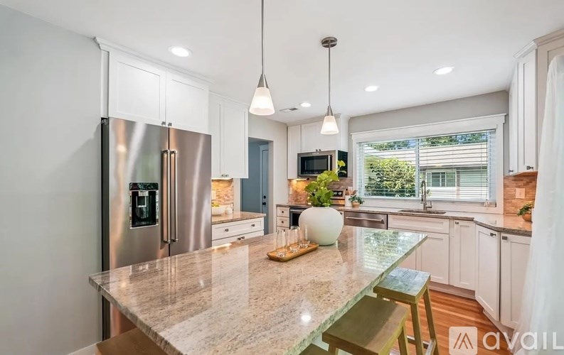A kitchen with a granite countertop and stainless steel appliances.