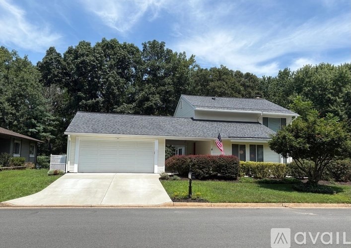 A house with a garage and a flag on the roof.