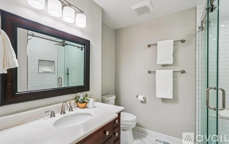 A bathroom with a white countertop and a large mirror.