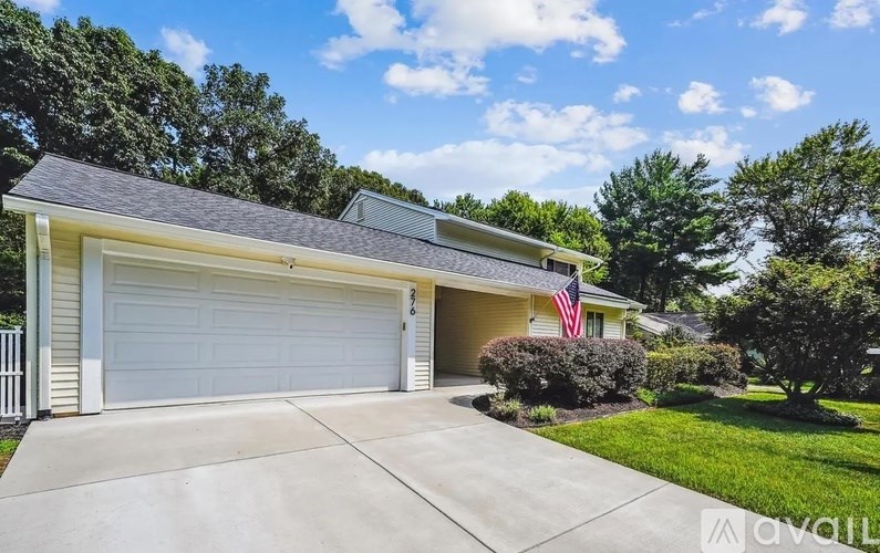 A house with a garage and an American flag on it.