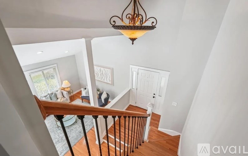 A chandelier hangs over a staircase in a home.