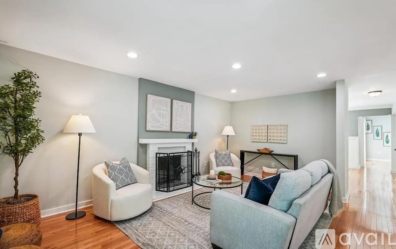 A living room with a fireplace, two couches, and a tree.