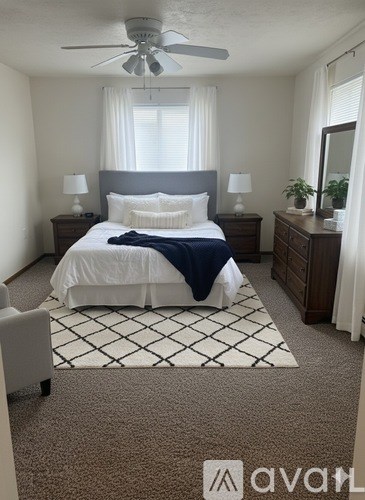 A bedroom with a bed, nightstands, and a ceiling fan.