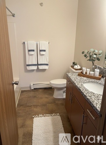 A bathroom with a toilet, sink, and towel rack.