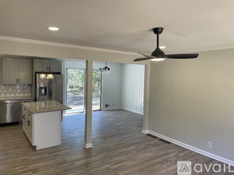 A spacious kitchen with a marble countertop and a ceiling fan.