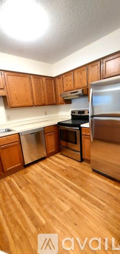 A kitchen with wooden cabinets and a wooden floor.