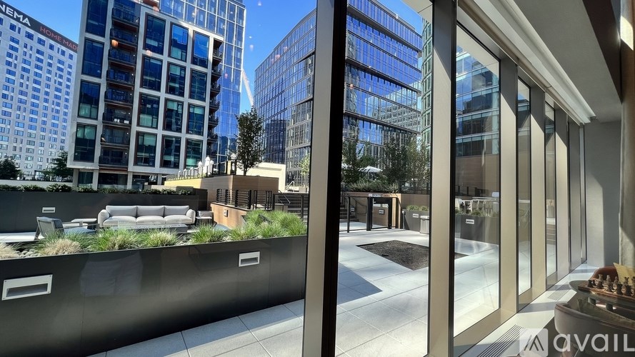 A modern building with a glass facade and a green rooftop garden.